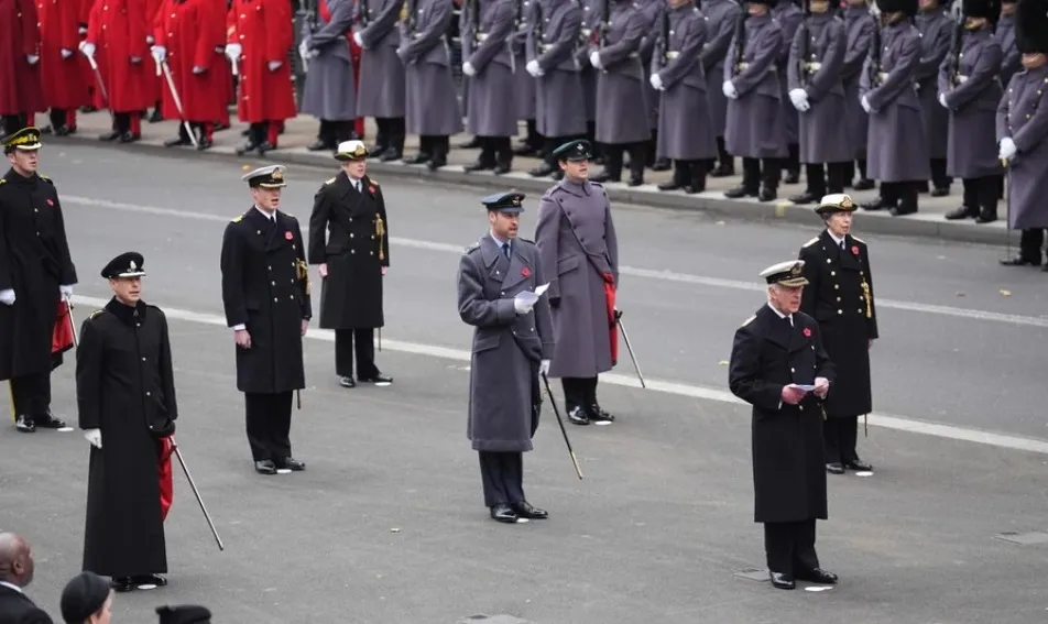 จากเดิมที่ปรินซ์แฮร์รีเสด็จเข้าร่วมพระราชพิธี Remembrance Sunday ในฐานะพระราชวงศ์ชั้นผู้ใหญ่แห่งพระราชตระกูลวินด์เซอร์ บัดนี้ พระองค์เลือกที่จะเป็นคนนอก และจึงต้องเฝ้าดูพระราชพิธีผ่านการถ่ายทอดสดในพระตำหนักมอนเตซิโตที่สหรัฐฯ ในภาพนี้ สมเด็จพระเจ้าชาร์ลส์ที่ 3 ทรงประทับยืนที่ด้านหน้าสุดในฐานะองค์ประธาน และในแถวที่สอง มีพระราชวงศ์ชั้นผู้ใหญ่ 3 พระองค์ทรงประทับยืนตามจุดที่มีมาร์กสีขาวดังนี้ เจ้าฟ้าชายวิลเลียม (ตรงกลางด้านหลังคิงชาร์ลส์) เจ้าชายเอ็ดเวิร์ด (ซ้ายสุด) และเจ้าฟ้าหญิงแอนน์ (ขวาสุด)